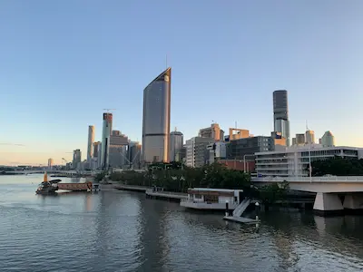 Panorámica del centro financiero de Brisbane visto desde el río Brisbane al atardecer, destino tendencia 2025 para turismo urbano y experiencias sostenibles en Australia. destinos tendencia 2025